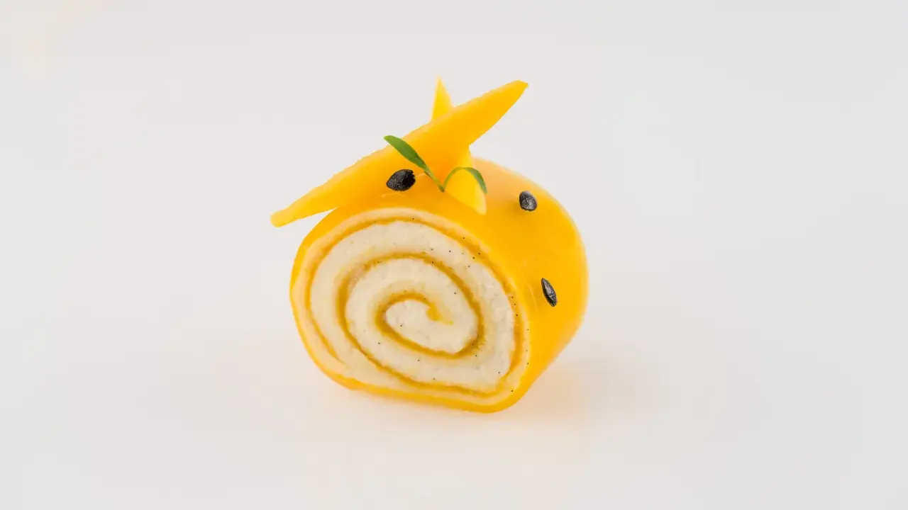 Un adorable petit roulé jaune, décoré comme un animal, montre ce que faire avec de la purée de fruits.