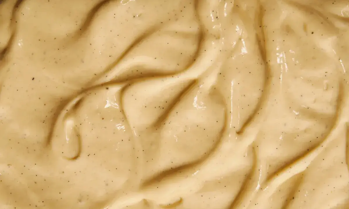Texture onctueuse de crème pâtissière mousseuse, parsemée de points de vanille.