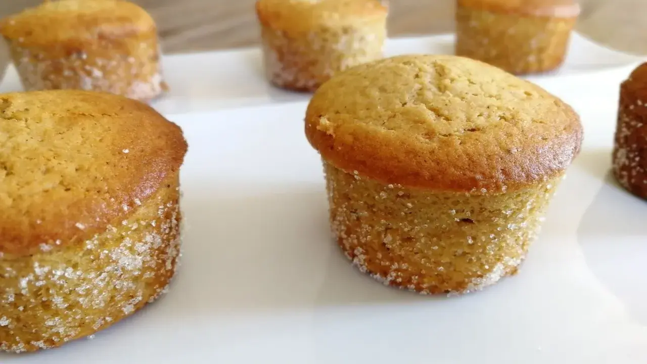 Six muffins dorés, certains légèrement inclinés, sur une assiette blanche. Peut-être que c'est pour ça que mes muffins gonflent de travers !