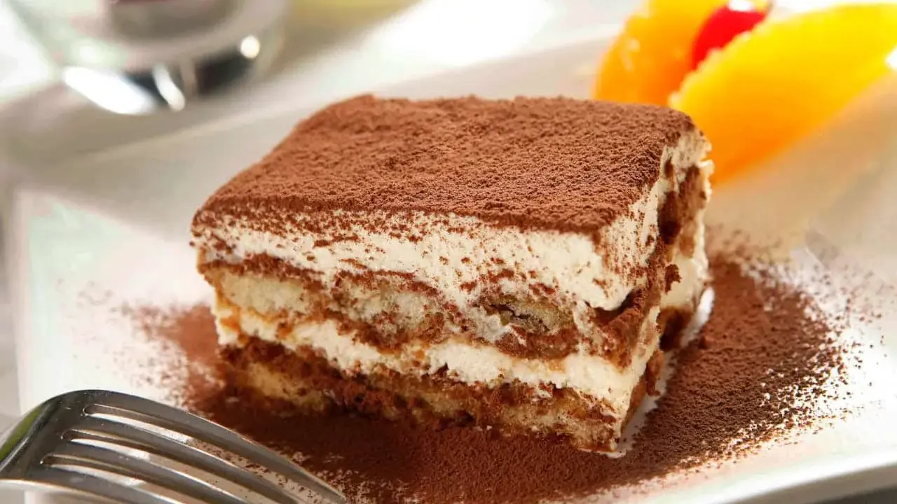 Un délicieux tiramisu, avec sa touche d'alcool subtile, saupoudré de cacao, prêt à être dégusté.