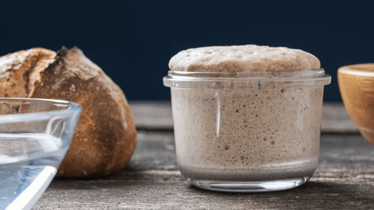 Un bocal de levain actif, plein de bulles, prêt à faire du pain. Ce type de levure est essentiel pour une mie aérée.