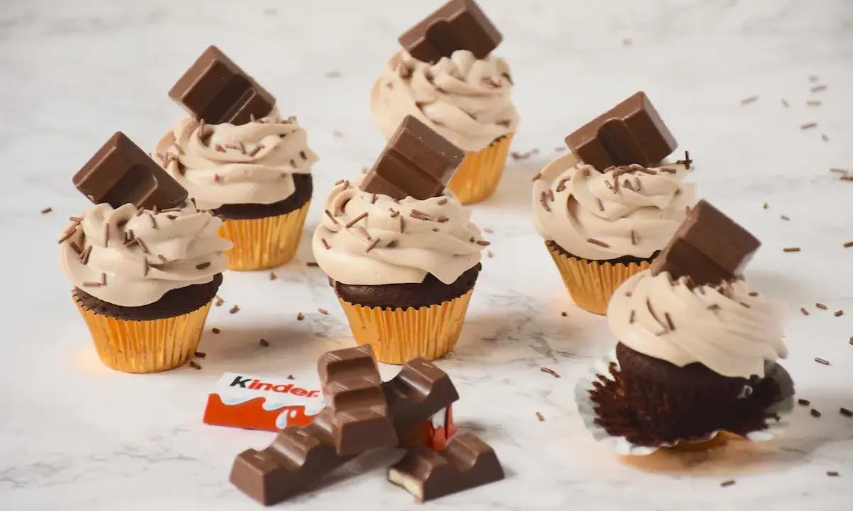 Cupcakes au chocolat avec ganache montée mascarpone, décorés de pépites et de barres Kinder. Un délice !