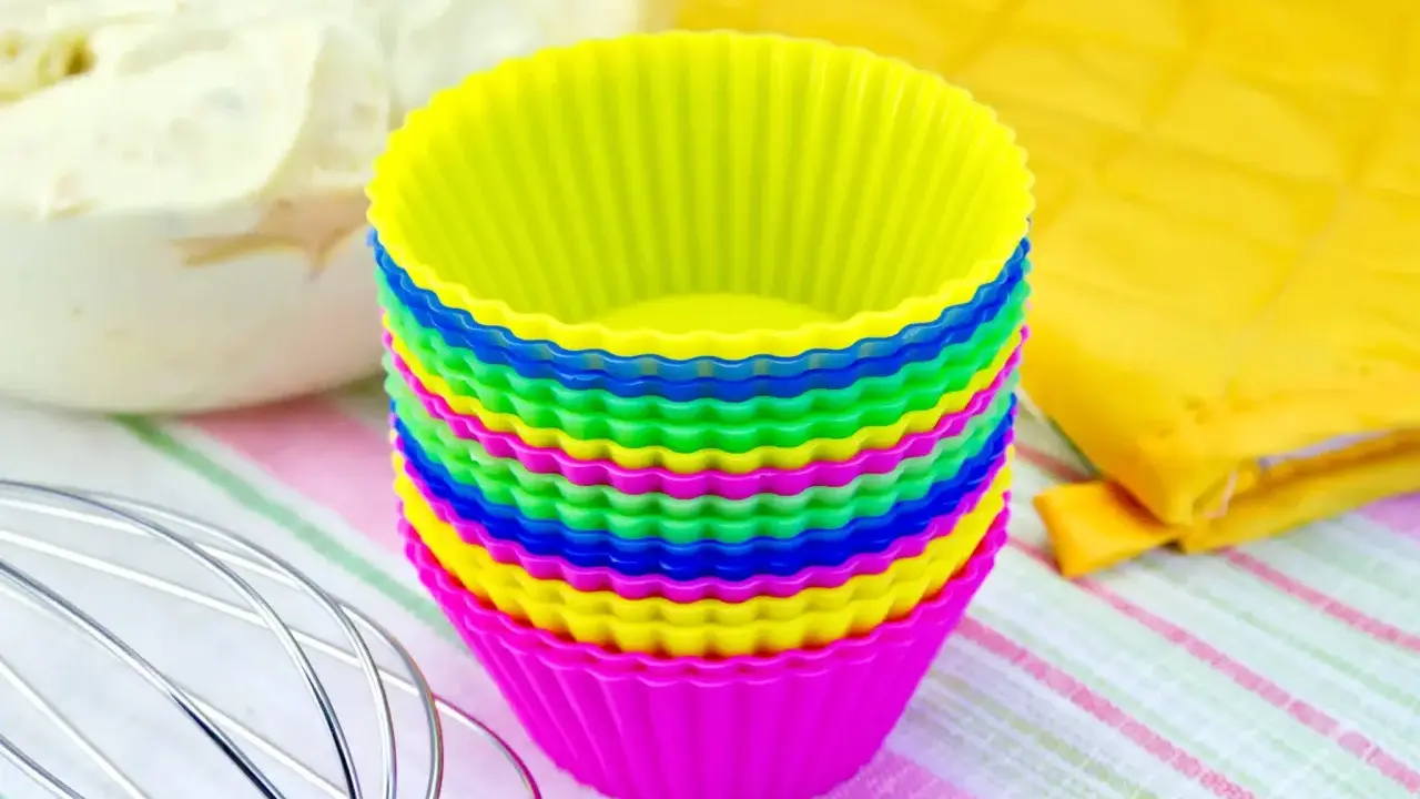 Pile de moules à cupcakes en silicone multicolores, prêts pour la pâtisserie. Apprenez comment nettoyer des moules en silicone pour qu'ils durent longtemps.