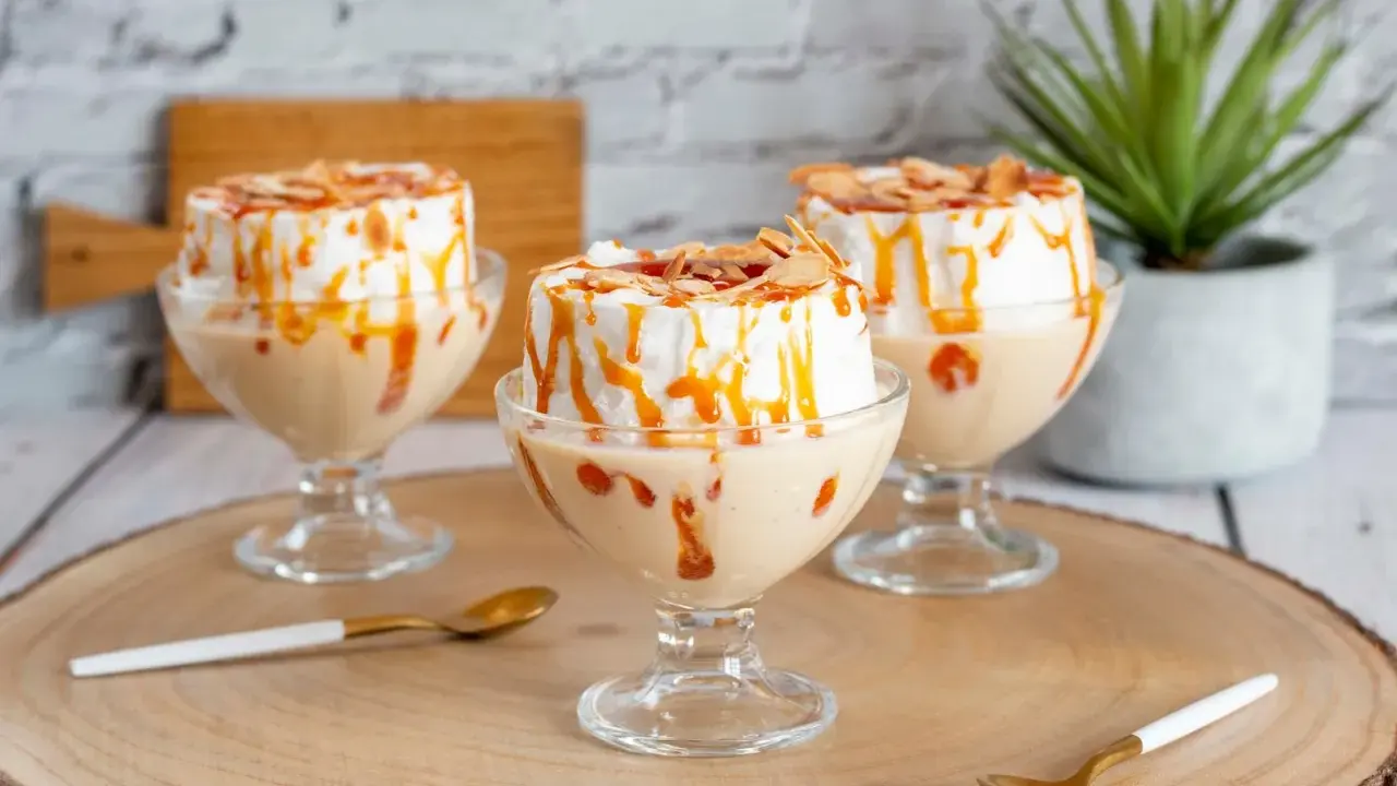 Comment faire une île flottante : trois desserts aériens à la meringue, nappés de caramel et d'amandes effilées, servis dans des coupes.