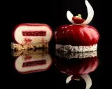 Un entremet rouge vif, miroir de la gourmandise. Une coupe révèle sa texture délicate, parfaite pour une recette entremet.