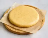 Pâte sablée crue, prête pour la conservation au frigo. Elle repose sur du papier sulfurisé, posé sur une planche en bois.