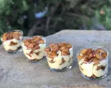 Quatre verrines mascarpone spéculoos, garnies de pommes caramélisées, sur une pierre.
