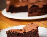 Une part de gâteau au chocolat intense, digne d'un chef pâtissier comme Pierre Hermé, sur une assiette blanche.