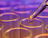 Goutte de colorant alimentaire liquide tombant d'une pipette dans un tube à essai.