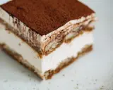 Une part de tiramisu onctueux, saupoudrée de cacao, prête à être dégustée. Une recette facile pour un dessert parfait.