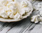 Douceur aérienne : des meringues comme celles de Cyril Lignac, croustillantes à souhait, sur une assiette vintage.