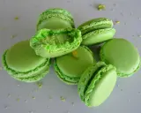 Macarons verts vifs, certains ouverts révélant une garniture crémeuse. Parfaits pour une recette ganache pistache sans chocolat blanc.
