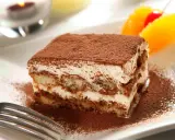 Un délicieux tiramisu, avec sa touche d'alcool subtile, saupoudré de cacao, prêt à être dégusté.