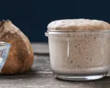Un bocal de levain actif, plein de bulles, prêt à faire du pain. Ce type de levure est essentiel pour une mie aérée.