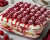 Tiramisu framboise, recette italienne. Un dessert crémeux et fruité, garni de framboises fraîches et d'un coulis rouge vif.