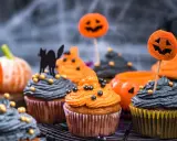 Cupcakes d'Halloween faciles décorés de glaçage orange et gris, de citrouilles et d'un chat noir. Parfait pour une fête effrayante !