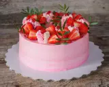Un délicieux gâteau fraise anniversaire rose, orné de fruits frais et de crème, prêt à célébrer un moment spécial.