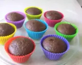 Huit cupcakes au chocolat, prêts à être dégustés, dans des moules colorés. Une recette de cupcake au chocolat facile et rapide.