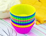 Pile de moules à cupcakes en silicone multicolores, prêts pour la pâtisserie. Apprenez comment nettoyer des moules en silicone pour qu'ils durent longtemps.