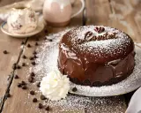 Un délicieux gateau d'anniversaire chocolat, nappé de glaçage brillant et saupoudré de sucre glace. Une touche de crème et des pépites de chocolat complètent cette gourmandise.
