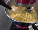 Une spatule ajoute une touche finale à une crème mousseline légère dans un robot pâtissier.