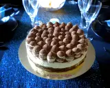 Un délicieux tiramisu revisité, parsemé de cacao, trône sur une table bleue scintillante, prêt à être dégusté.