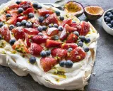 Pavlova inratable garnie de fraises, myrtilles et fruits de la passion. Un délice croustillant à l'extérieur et moelleux à l'intérieur.