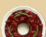 Gâteau angel cake au chocolat, décoré de framboises, de gelée rouge et de romarin.