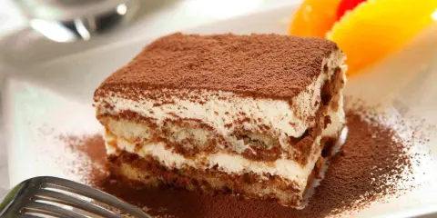 Un délicieux tiramisu, avec sa touche d'alcool subtile, saupoudré de cacao, prêt à être dégusté.