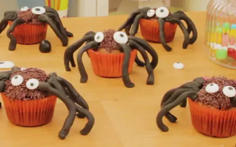 Des cupcakes d'Halloween transformés en araignées effrayantes avec des vermicelles chocolat et des yeux en sucre. Parfait pour une fête !