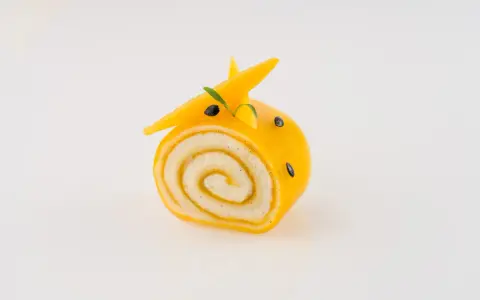 Un adorable petit roulé jaune, décoré comme un animal, montre ce que faire avec de la purée de fruits.