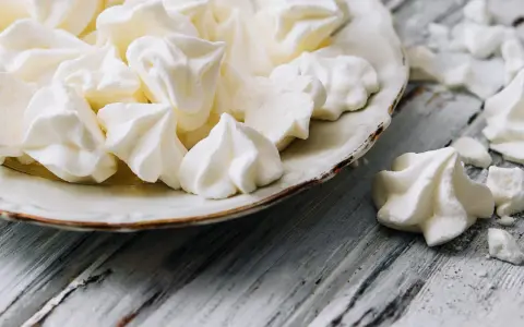 Douceur aérienne : des meringues comme celles de Cyril Lignac, croustillantes à souhait, sur une assiette vintage.