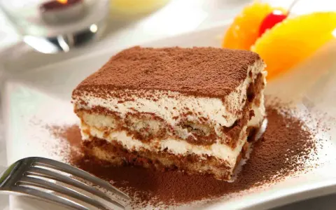 Un délicieux tiramisu, avec sa touche d'alcool subtile, saupoudré de cacao, prêt à être dégusté.