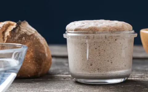 Un bocal de levain actif, plein de bulles, prêt à faire du pain. Ce type de levure est essentiel pour une mie aérée.