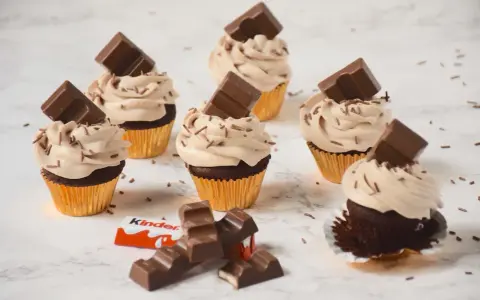 Cupcakes au chocolat avec ganache montée mascarpone, décorés de pépites et de barres Kinder. Un délice !