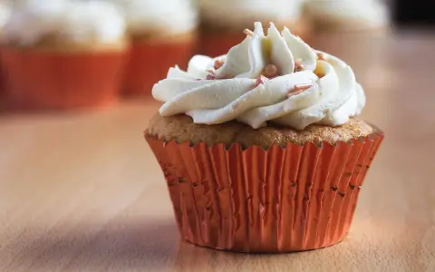 Un cupcake orné d'une ganache montée au chocolat blanc, prêt à être dégusté. Une recette simple pour un dessert gourmand.