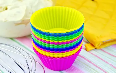 Pile de moules à cupcakes en silicone multicolores, prêts pour la pâtisserie. Apprenez comment nettoyer des moules en silicone pour qu'ils durent longtemps.