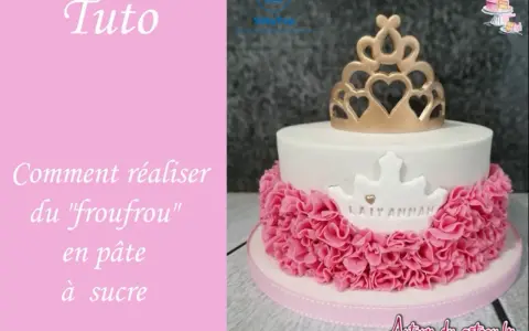 Gâteau d'anniversaire en pâte à sucre blanc orné d'une couronne dorée et d'un "froufrou" rose.