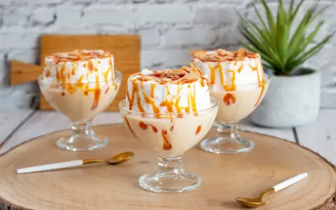 Comment faire une île flottante : trois desserts aériens à la meringue, nappés de caramel et d'amandes effilées, servis dans des coupes.