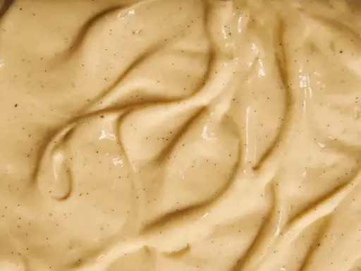 Texture onctueuse de crème pâtissière mousseuse, parsemée de points de vanille.