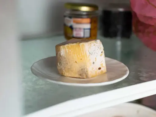 Un morceau de fromage moisi sur une assiette. Combien de temps ce gâteau périmé est-il resté au réfrigérateur ?