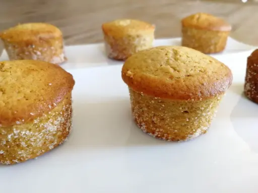 Six muffins dorés, certains légèrement inclinés, sur une assiette blanche. Peut-être que c'est pour ça que mes muffins gonflent de travers !
