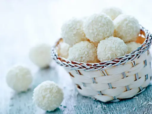 Délicieuses boules coco, parfaites pour une recette facile et rapide. Un panier rempli de ces douceurs vous attend.