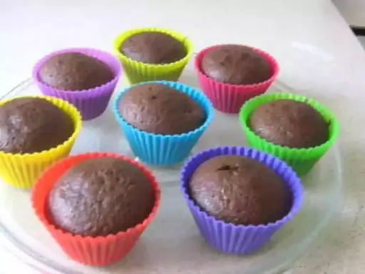 Huit cupcakes au chocolat, prêts à être dégustés, dans des moules colorés. Une recette de cupcake au chocolat facile et rapide.