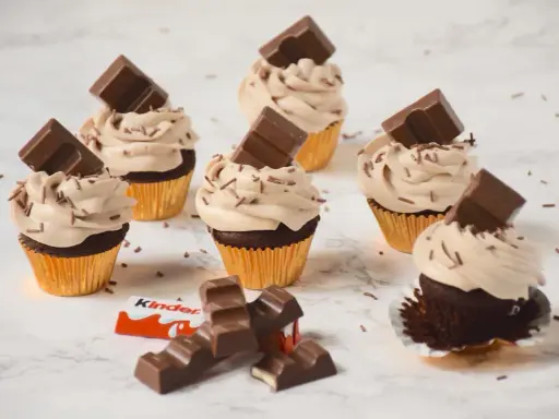 Cupcakes au chocolat avec ganache montée mascarpone, décorés de pépites et de barres Kinder. Un délice !