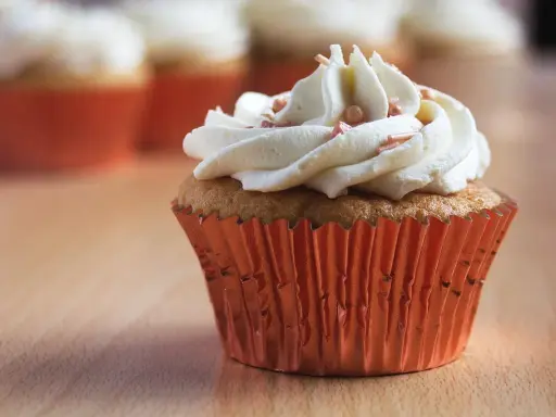 Un cupcake orné d'une ganache montée au chocolat blanc, prêt à être dégusté. Une recette simple pour un dessert gourmand.