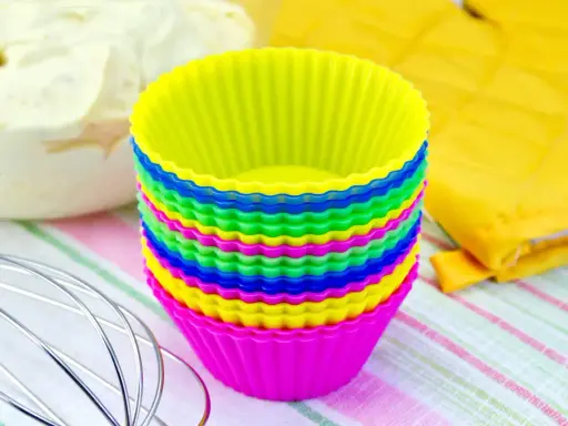 Pile de moules à cupcakes en silicone multicolores, prêts pour la pâtisserie. Apprenez comment nettoyer des moules en silicone pour qu'ils durent longtemps.