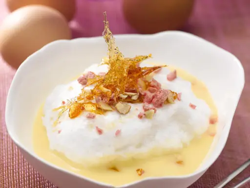 Île flottante aérienne, une recette avec beaucoup d'œufs, garnie de caramel croquant et d'éclats roses.