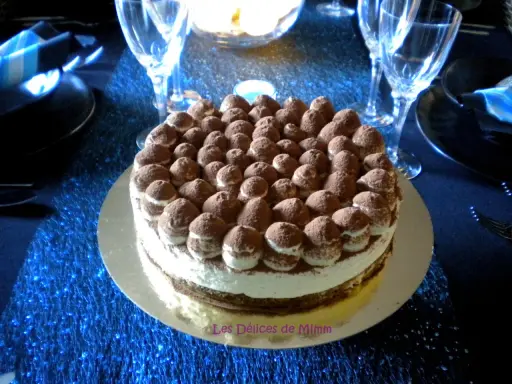 Un délicieux tiramisu revisité, parsemé de cacao, trône sur une table bleue scintillante, prêt à être dégusté.