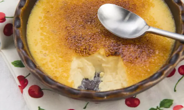 Crème brûlée avec une croûte caramélisée craquante. Une cuillère est posée sur le dessert, parfait pour une recette de crème brûlée facile et rapide.